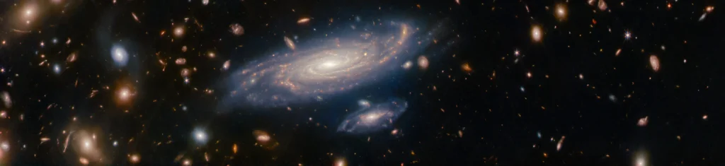 Galaxia espiral captada por el telescopio James Webb rodeada de miles de galaxias distantes, una imagen que ilustra la escala cósmica en el corazón del existencialismo cósmico